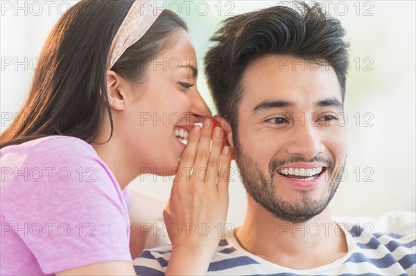 Woman whispering to man's ear.