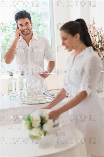 Business owners preparing dining table.