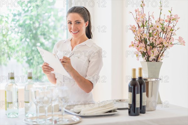 Woman preparing table in restaurant.