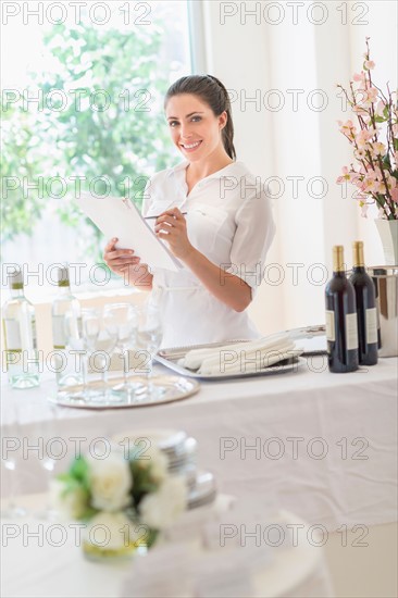 Woman preparing table in restaurant.