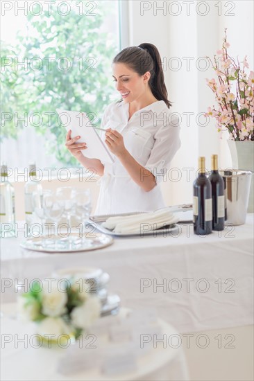 Woman preparing table in restaurant.