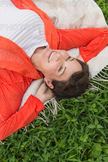 Mature woman lying on grass.