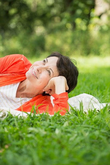 Mature woman lying on grass.