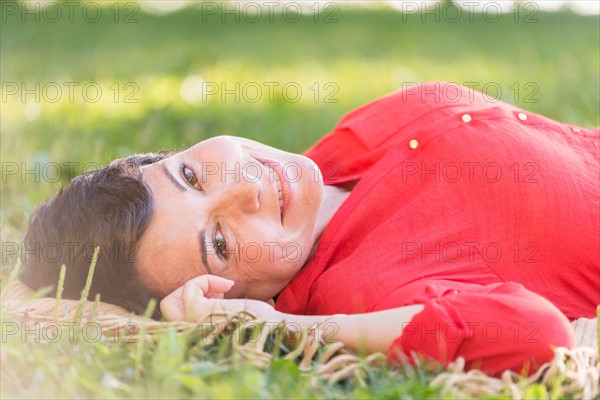 Mature woman lying on grass.