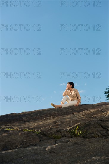 Mature woman sitting on rock.