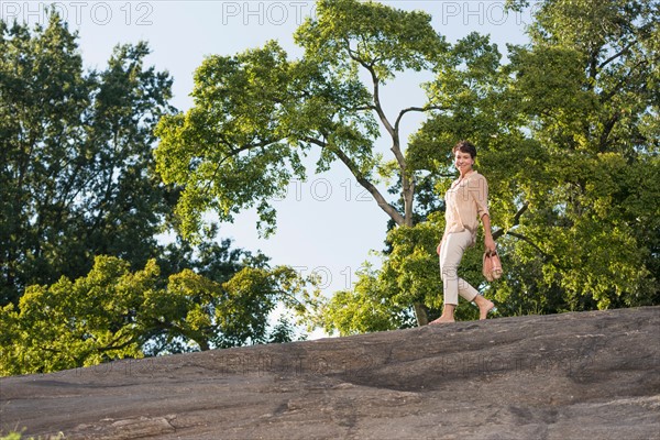 Mature woman walking on rock.