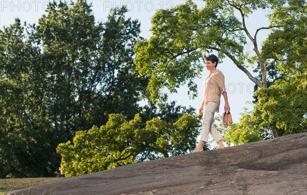 Mature woman walking on rock.