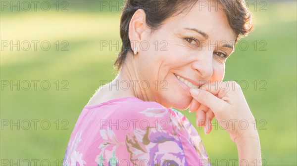 Portrait of mature woman smiling outdoors.