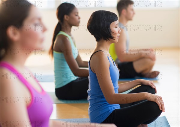 Group of young people meditating .