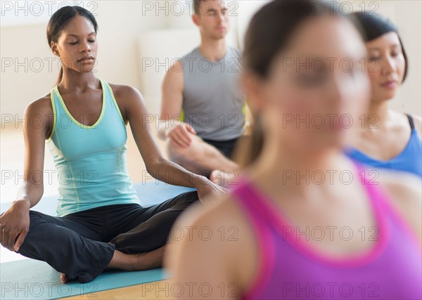 Group of young people meditating .