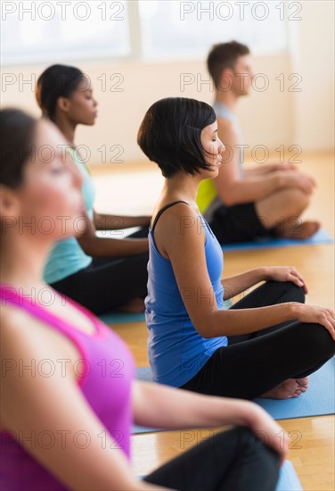 People training yoga in gym.