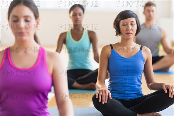 People training yoga in gym.