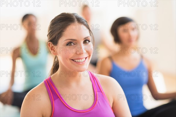 Portrait of smiling woman training yoga in gym.