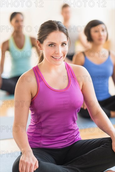 Portrait of smiling woman training yoga in gym.