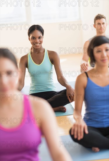 People training yoga in gym.