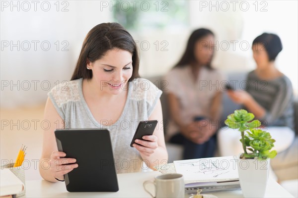 Woman using digital tablet and mobile phone.