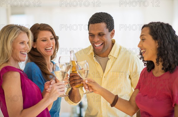 Friends making toast at party.