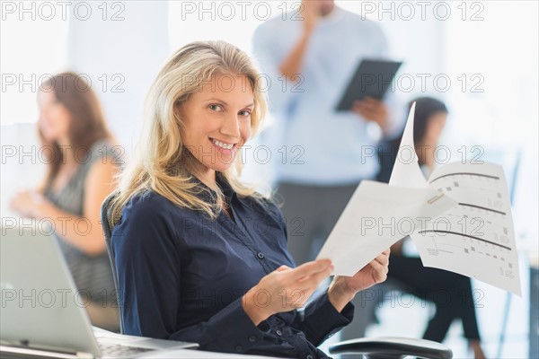 Woman smiling at desk in office.