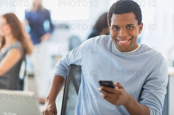 Man smiling at desk in office.