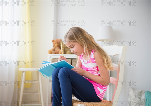 Girl (8-9) writing diary