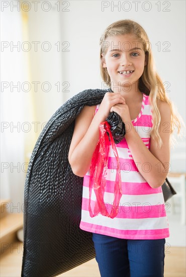 Girl (8-9) carrying bag with trash