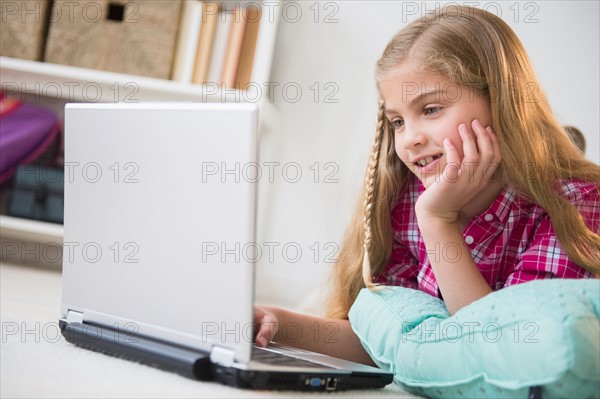 Girl (8-9) using laptop