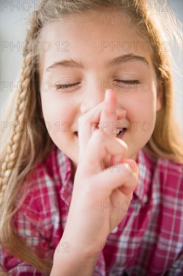 Portrait of girl (8-9) wishing with fingers crossed