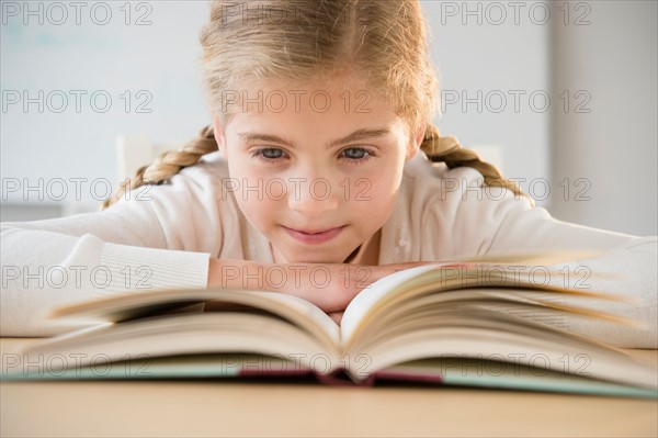 Portrait of girl (8-9) reading book