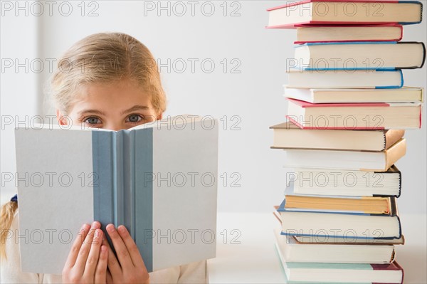 Portrait of girl (8-9) reading book