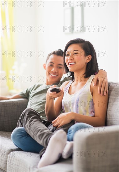 Young woman and young man sitting on sofa