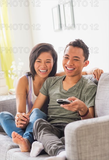 Young woman and young man sitting on sofa