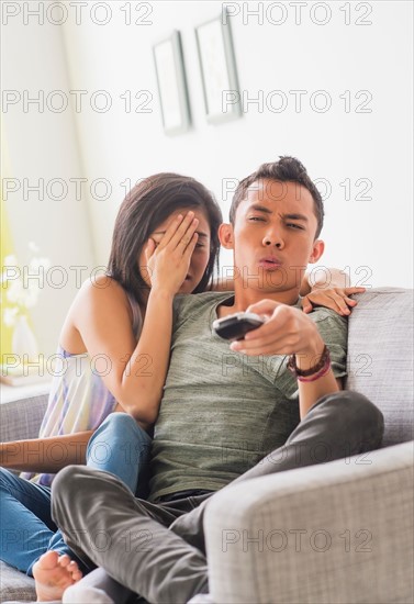 Young woman and young man sitting on sofa