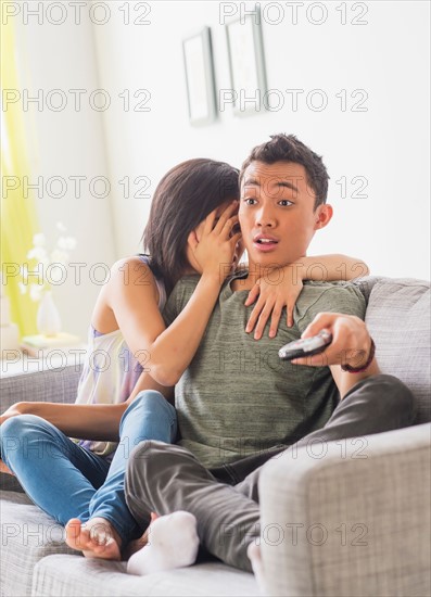 Young woman and young man sitting on sofa
