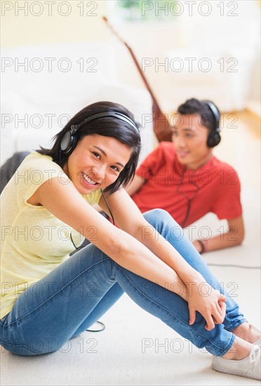 Young woman and man listening music with headphones on