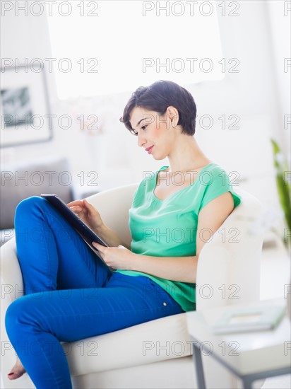 Portrait of young woman using digital tablet at home