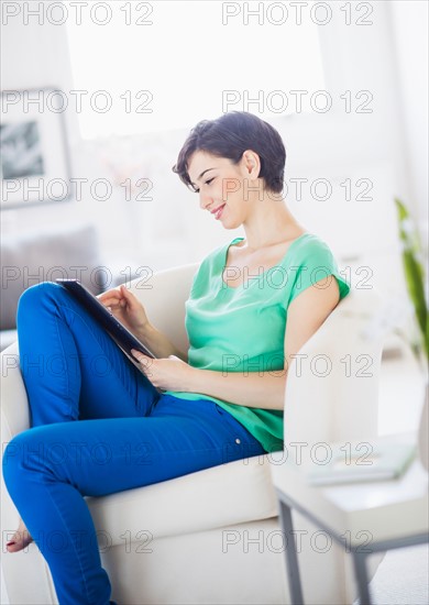 Portrait of young woman using digital tablet at home