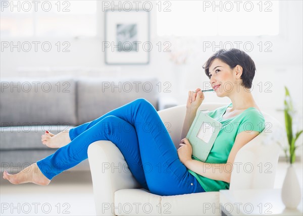 Portrait of woman holding note pad and pencil