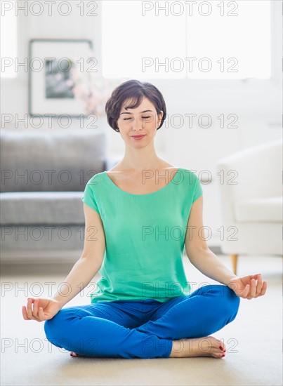 Young woman meditating at home