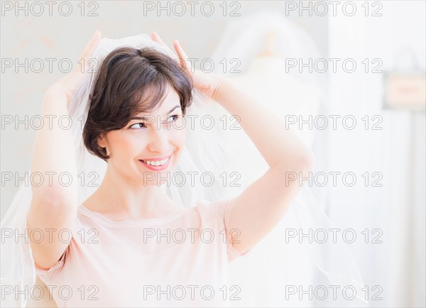 Portrait of woman trying on wedding veil