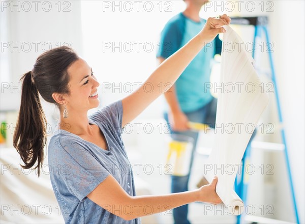 Woman looking at wallpaper, man in background