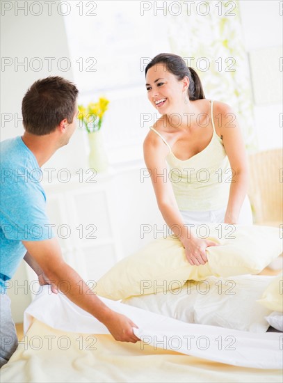 Couple making bed