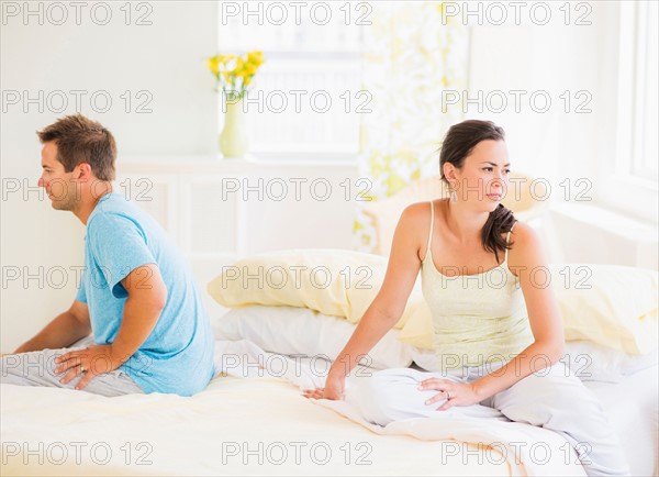 Sad couple sitting on bed