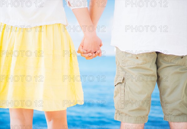 Studio Shot Mid section of couple standing and holding hands