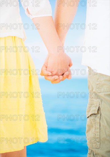 Studio Shot Mid section of couple standing and holding hands