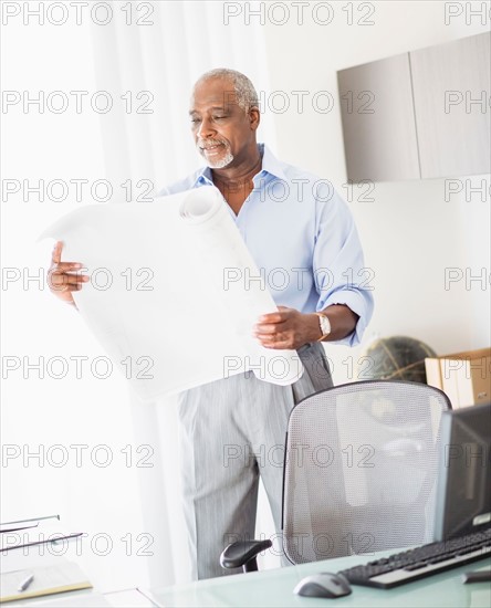 Portrait of senior man holding blueprint