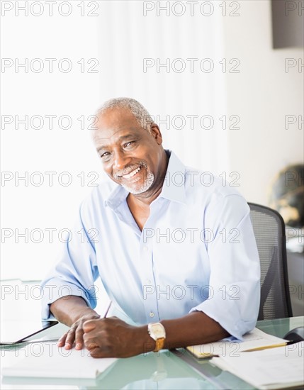 Portrait of senior man writing in office