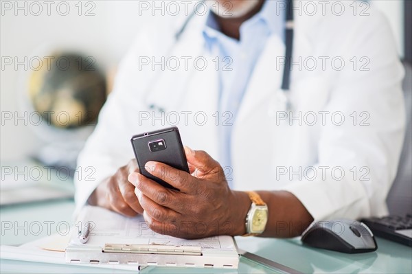 Close up of doctor's hand holding mobile phone