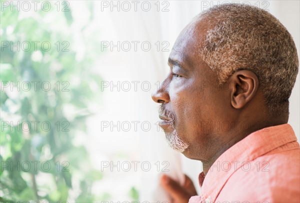 Portrait of man looking through window