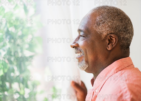 Portrait of smiling man looking through window