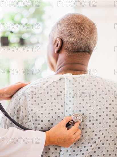 Doctor using stethoscope on patient